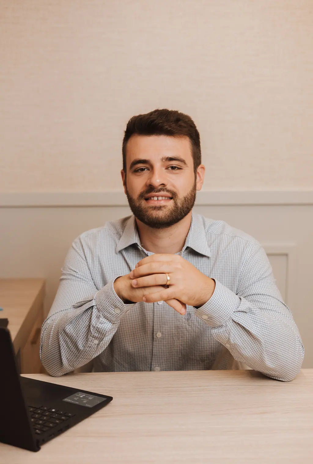 Dr. Lucas Vitório, psiquiatra em Tubarão/SC, sorrindo à mesa do consultório