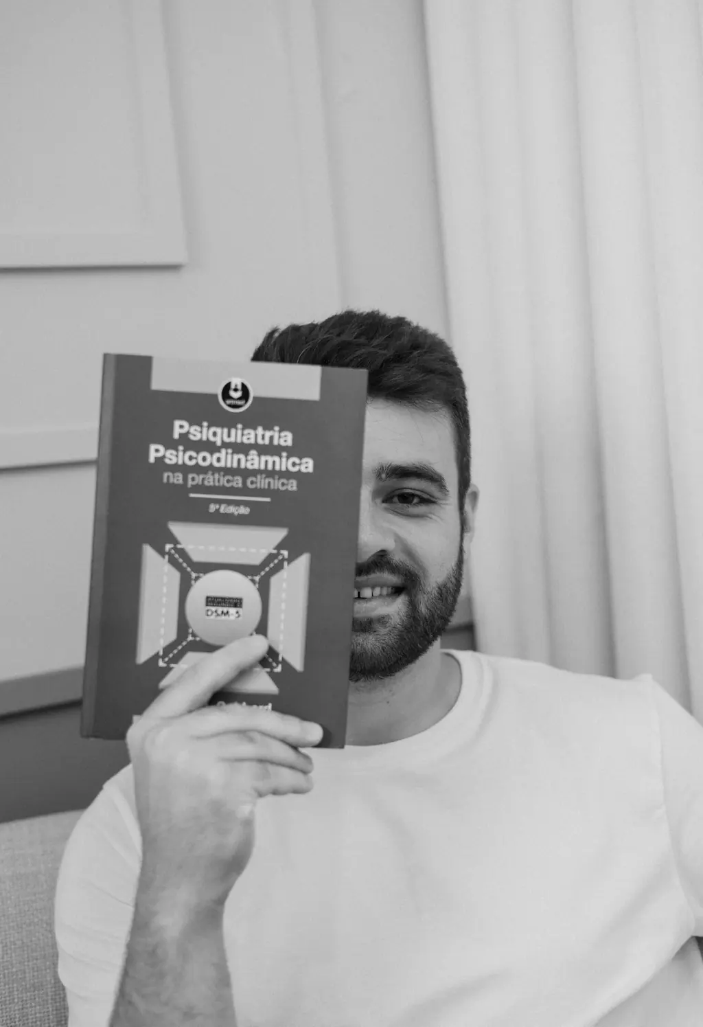 Dr. Lucas Vitório segurando o livro Psiquiatria Psicodinâmica na Prática Clínica